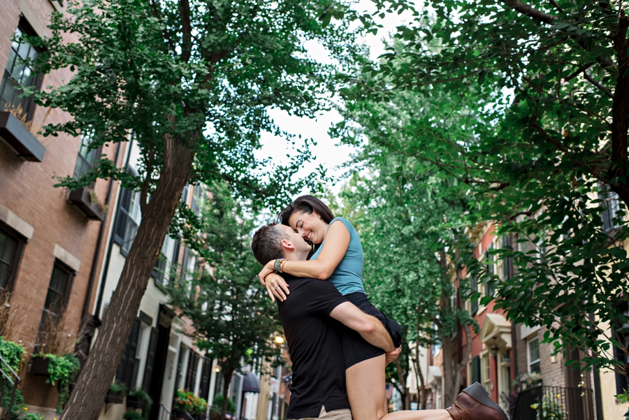 A man lifts his fiance up for an epic kiss on a beautiful center city block in Philly.
